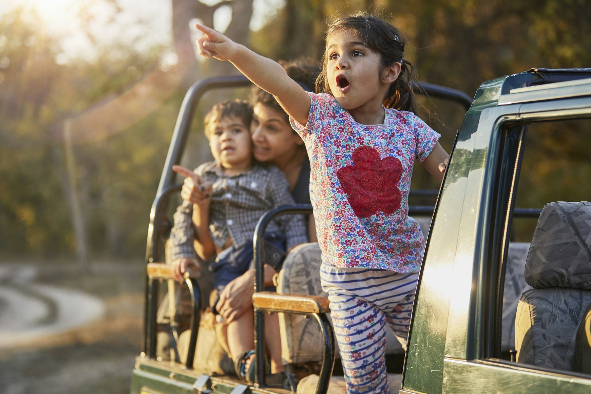 A mother and two kids enjoying a safari in an off-road vehicle in India