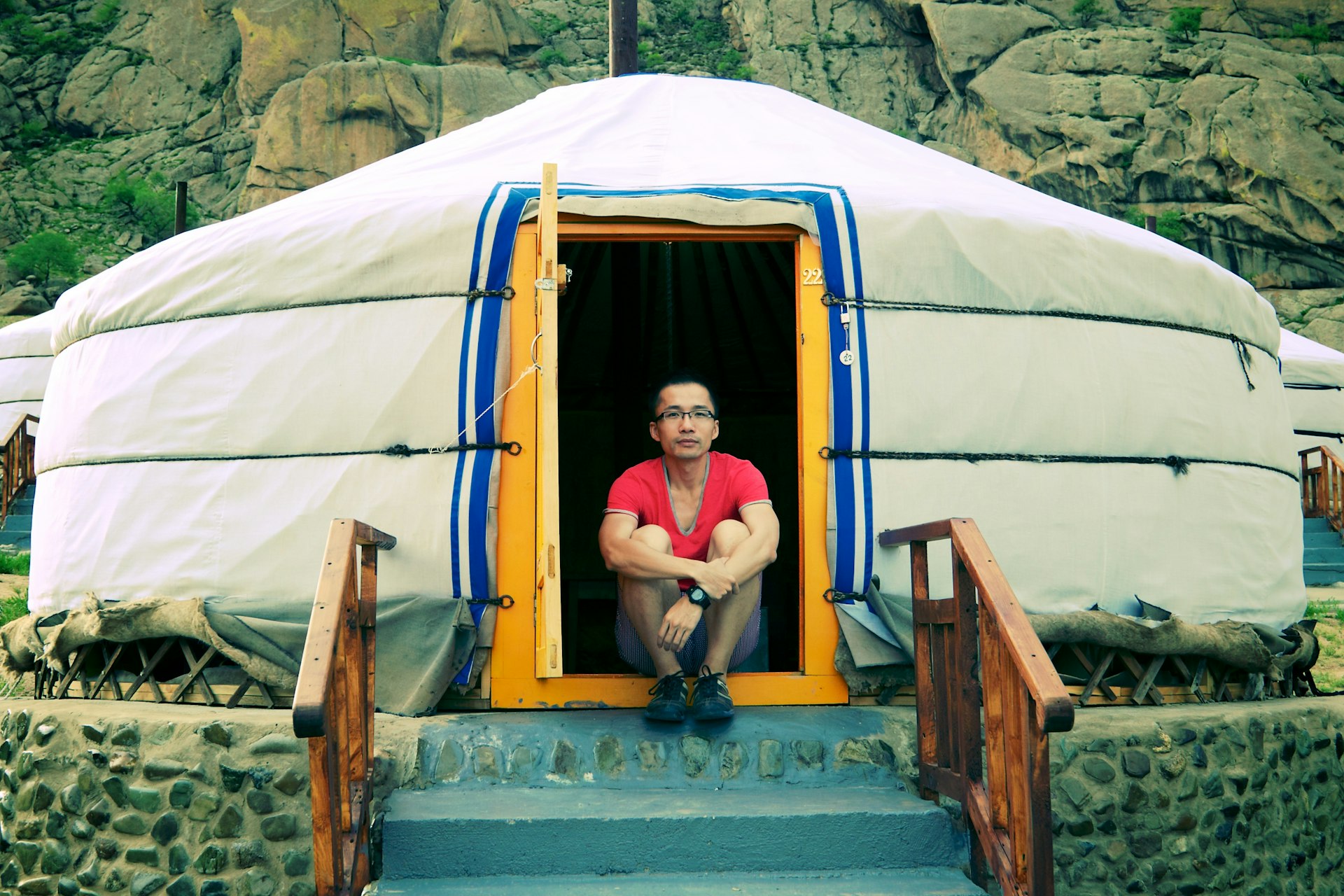 A man sitting in the doorway of a Mongolian ger