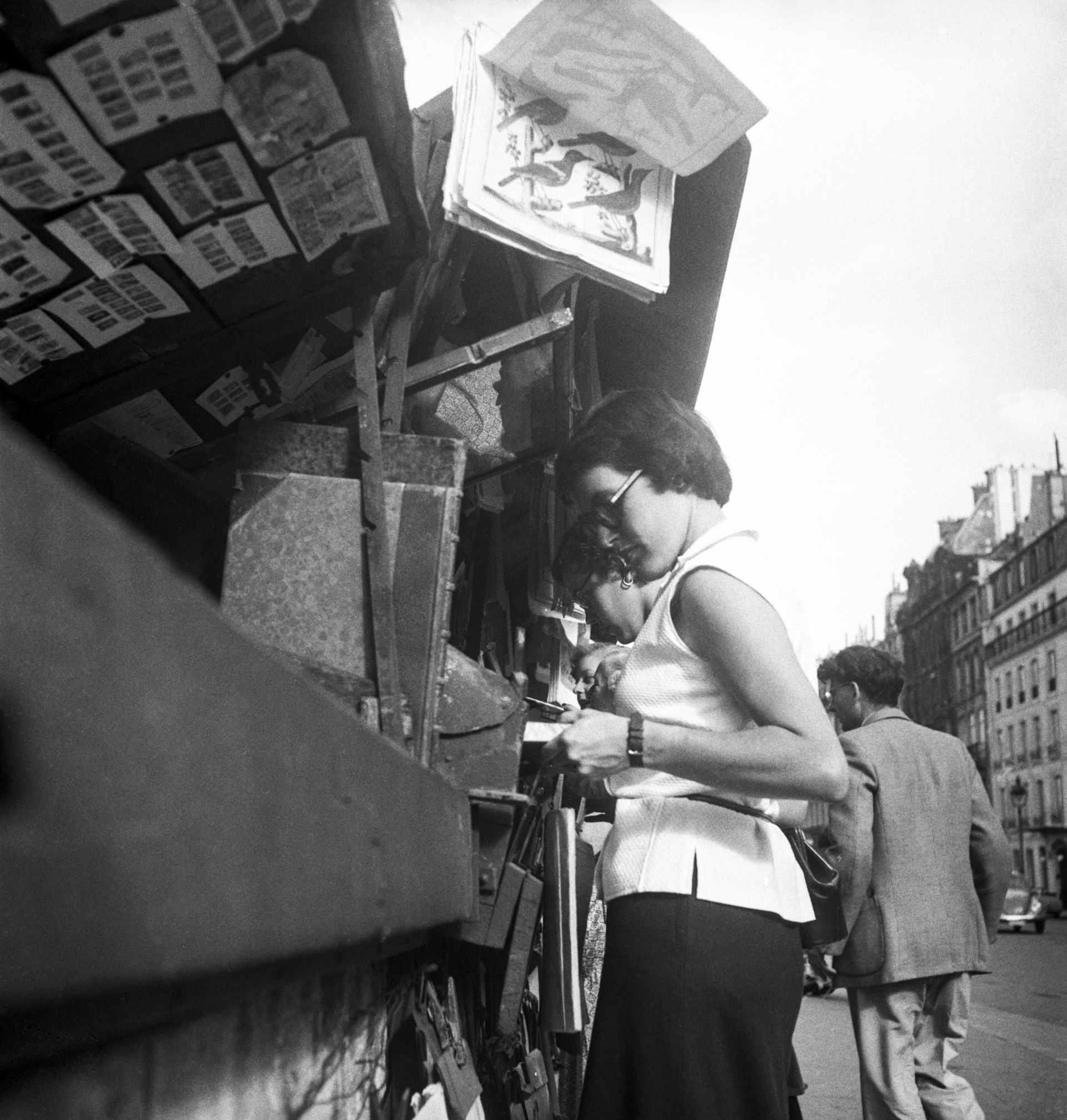 A woman browsing the bookstalls by the Seine in 1951