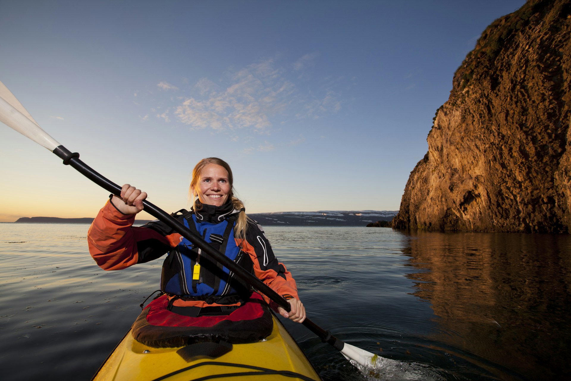 Woman kayaking in Iceland with a smile on her face