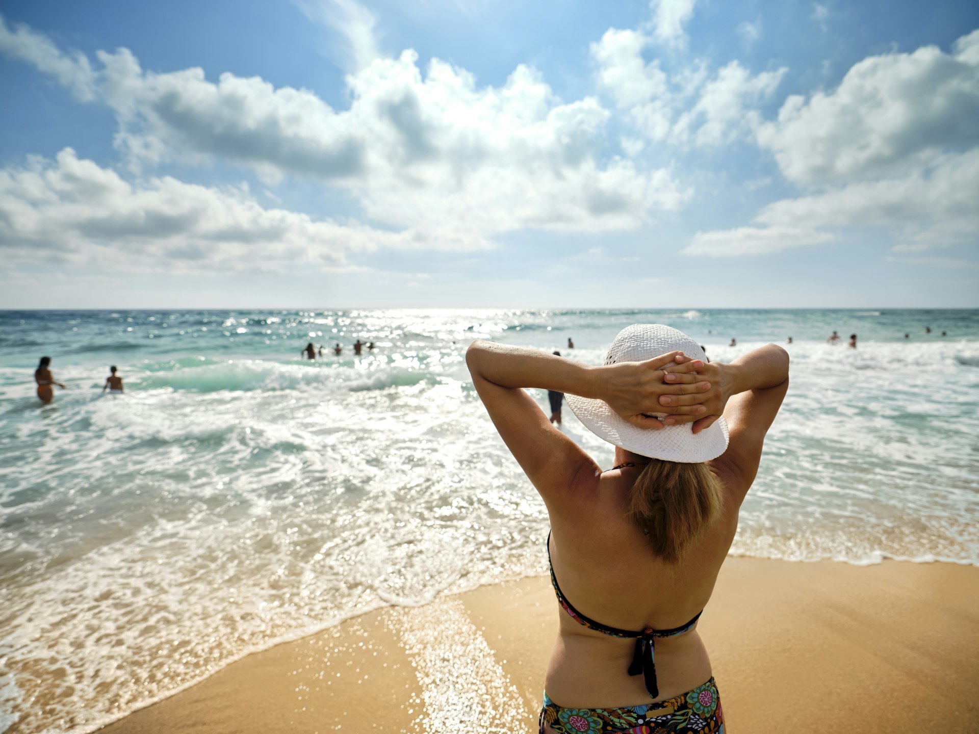 A woman looking out at the sea on a beach on the Gulf of Policastro in southern Italy 