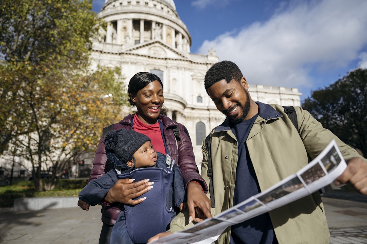 Front view of Black man and woman in mid 20s with 4 month old baby standing outside St. Paulâ€™s Cathedral and planning further sightseeing.
Front view of Black man and woman in mid 20s with 4 month old baby standing outside St. Paul’s Cathedral and planning further sightseeing.
1443819126
Two parents and their baby on holiday in London with St Paul's Cathedral in the background