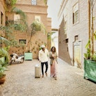 Wide shot of smiling and laughing couple arriving in hotel courtyard with rolling luggage while on vacation
1463514193
exotic travel
A smiling and laughing couple arriving in a hotel courtyard with luggage in Marrakech