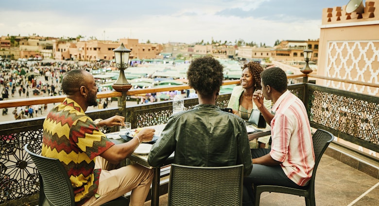 Medium shot of smiling friends sharing food and drink at rooftop restaurant overlooking Jamaa el Fna Square during vacation in Marrakech
1466439690
exotic travel