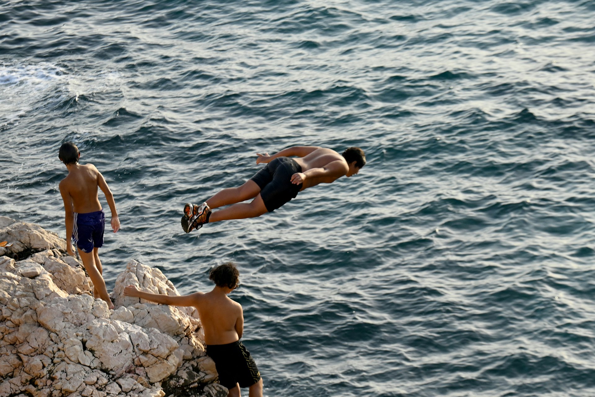 Young men dive into the Mediterranean Sea in Marseille, France