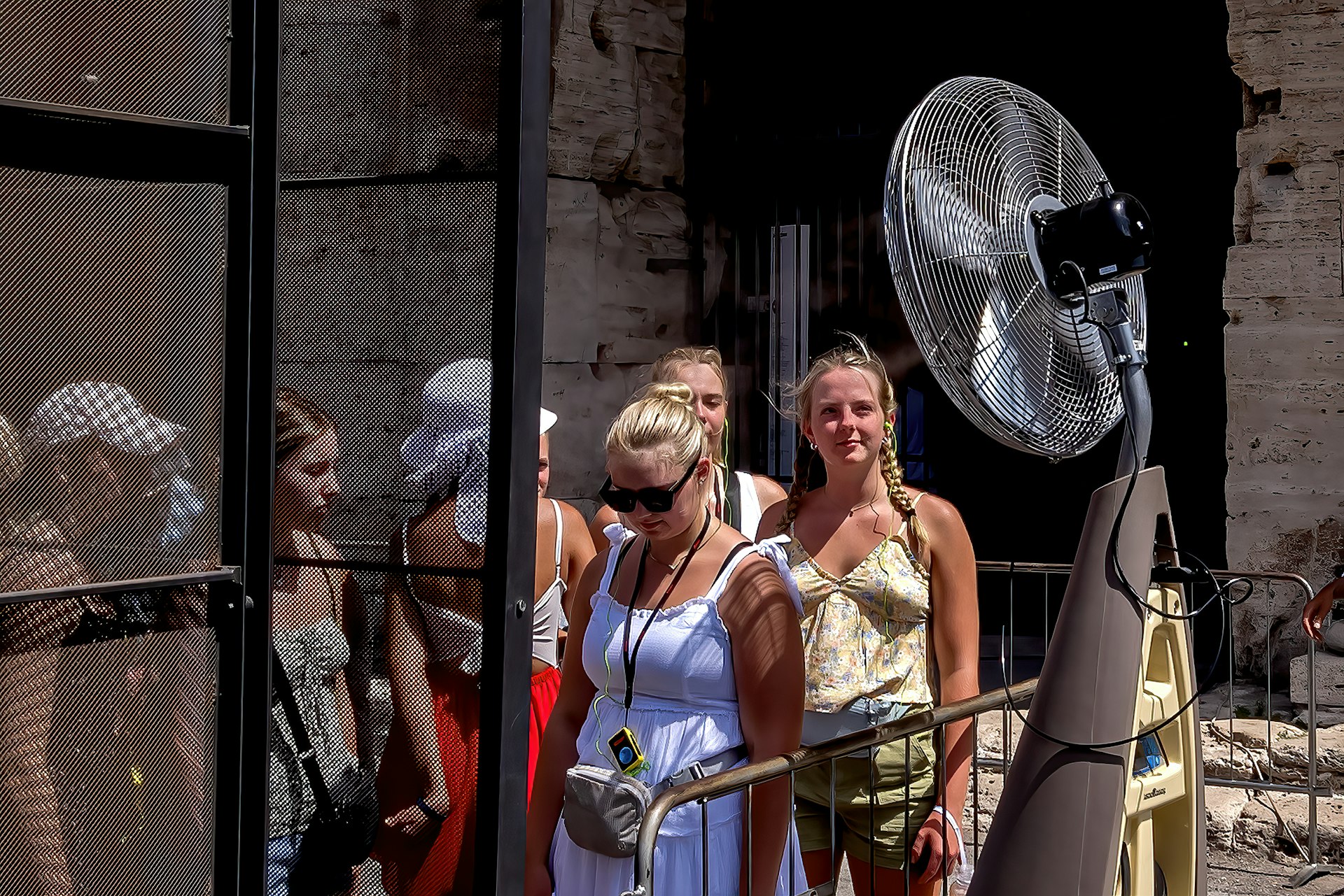 Tourists are refreshed by a fan spraying nebulized water at Colosseo area (Colosseum), Rome, Italy