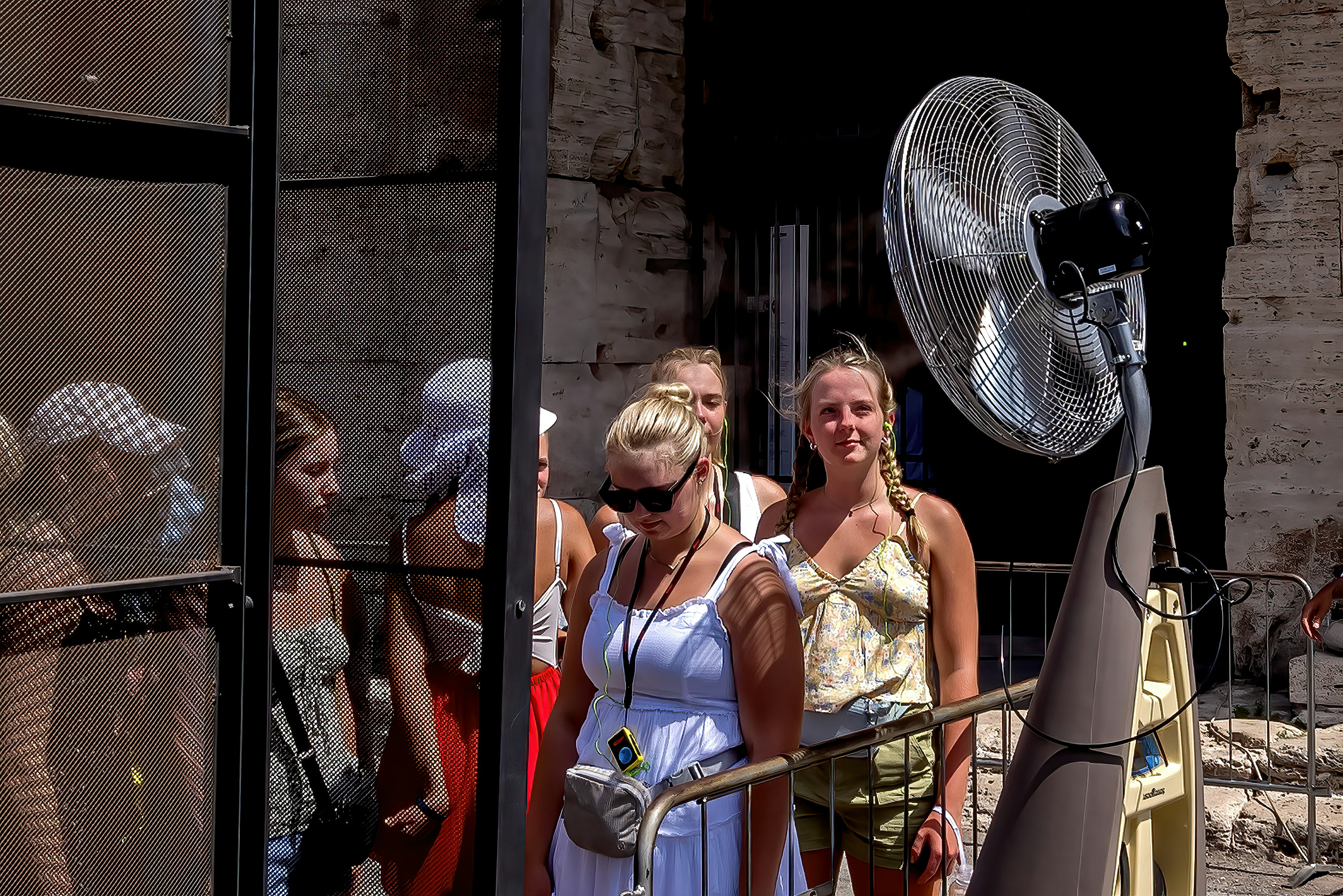 Tourists are refreshed by a fan spraying nebulized water at Colosseo area (Colosseum), Rome, Italy