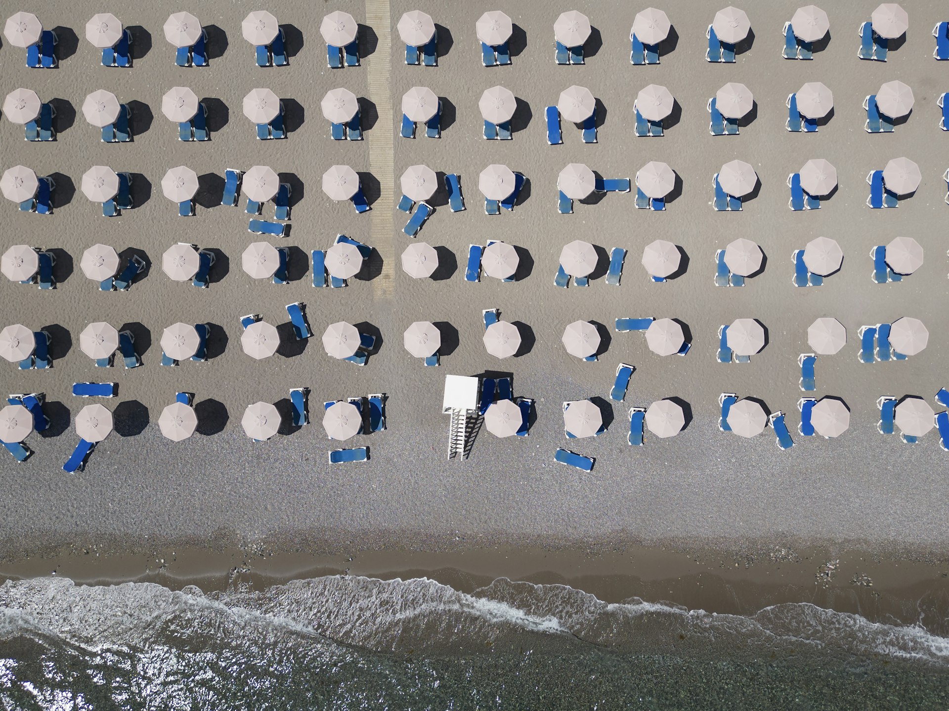 In this aerial view empty sun loungers line the beach at a resort on July 29, 2023 in Lardos, Rhodes, Greece.