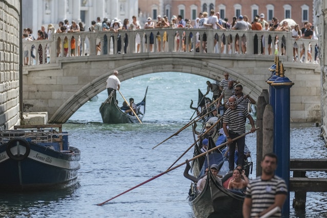 VENICE, ITALY - AUGUST 02: Gondoliers proceed slowly near the Sospiri Bridge near St. Mark's Square due to too much traffic on August 02, 2023 in Venice, Italy. UNESCO officials have included Venice and its lagoon to the list of world heritage in danger to review, along with Ukraine's Kyiv, and Lviv. The UN cultural agency deems Italy not effective in protecting Venice from mass tourism and extreme weather conditions. (Photo by Stefano Mazzola/Getty Images)