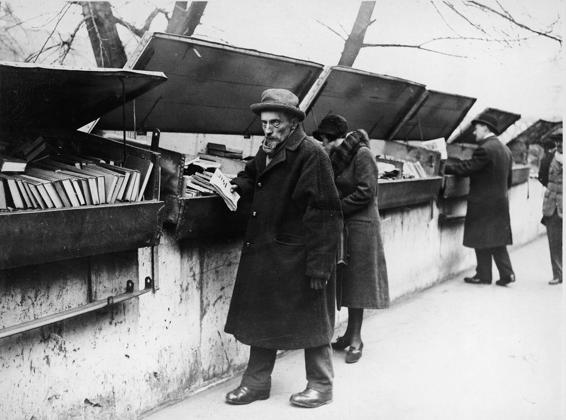 A bookseller by his bookstall on the Seine quayside in the 1920s