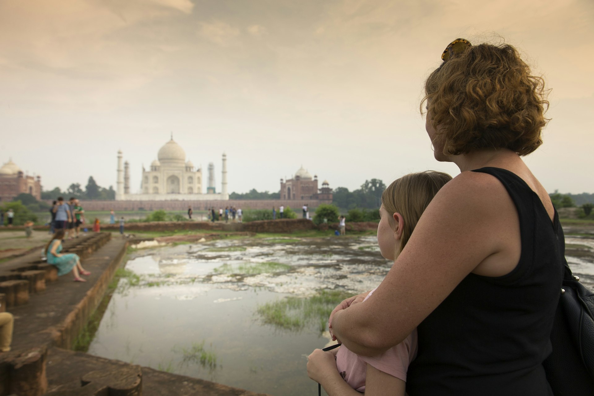 A mother and daughter watching The Taj Mahal at sunset