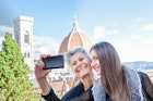 autumn, outdoor, daylight, city, city break, holiday, travel, vacation, travel destination, casual clothes, mother, daughter, long hair, smiling, happy, holding, landscape, panoramic view, blue sky, happiness, enjoyment, togetherness, mob,ile phone, technology, taking photo, arm raised, looking at, selfie