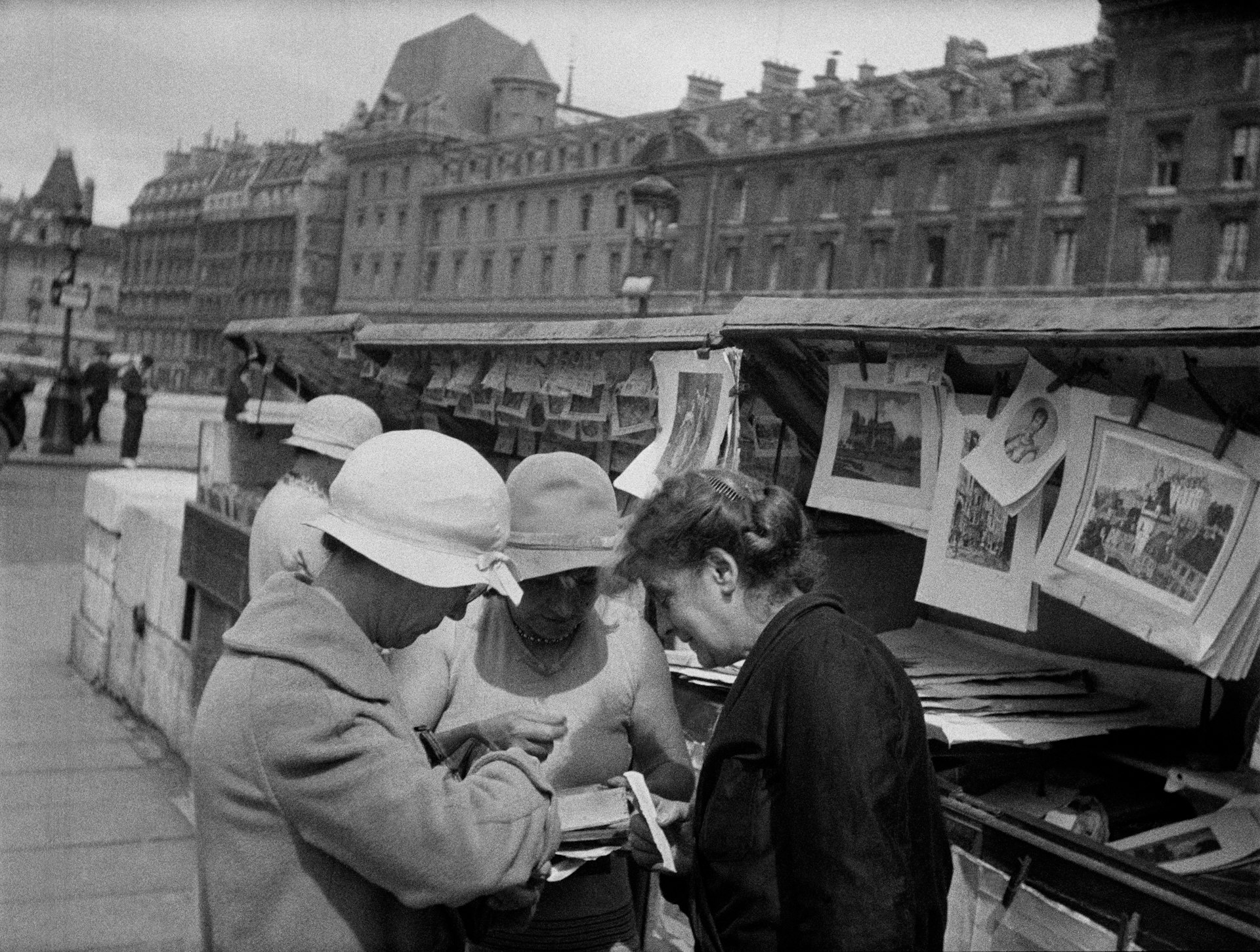 Fashionable women browse for books along the Seine