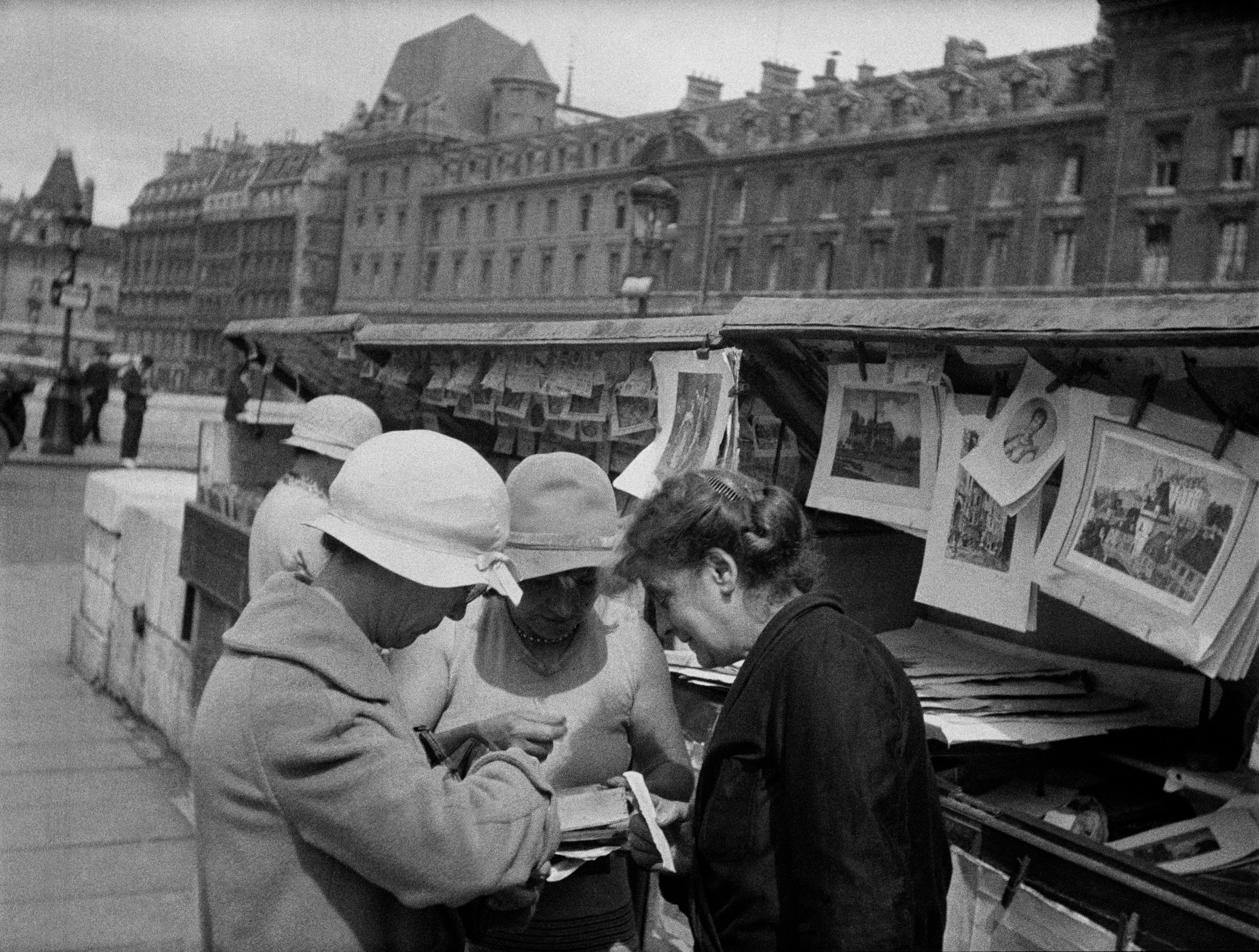 Fashionable women browse for books along the Seine