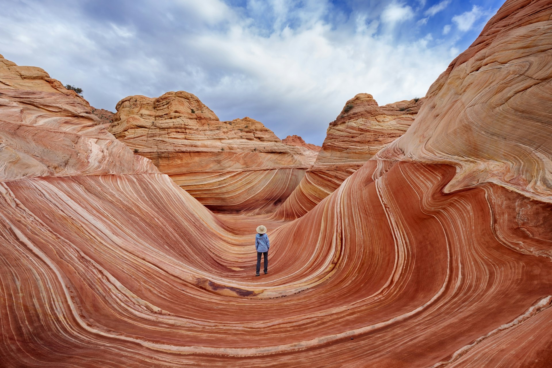 A woman stands among rock formations that appear to curve around her
