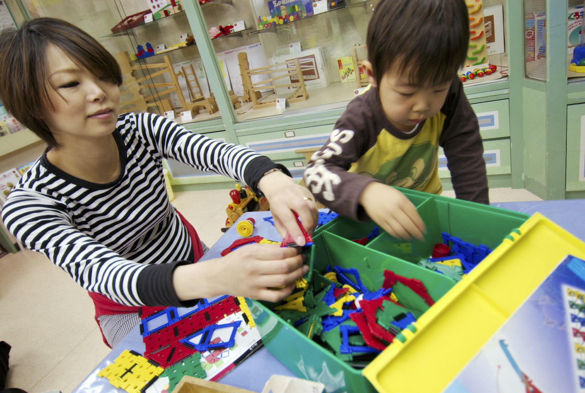 A mother and son playing with a box of toys at Nakano Toy Museum