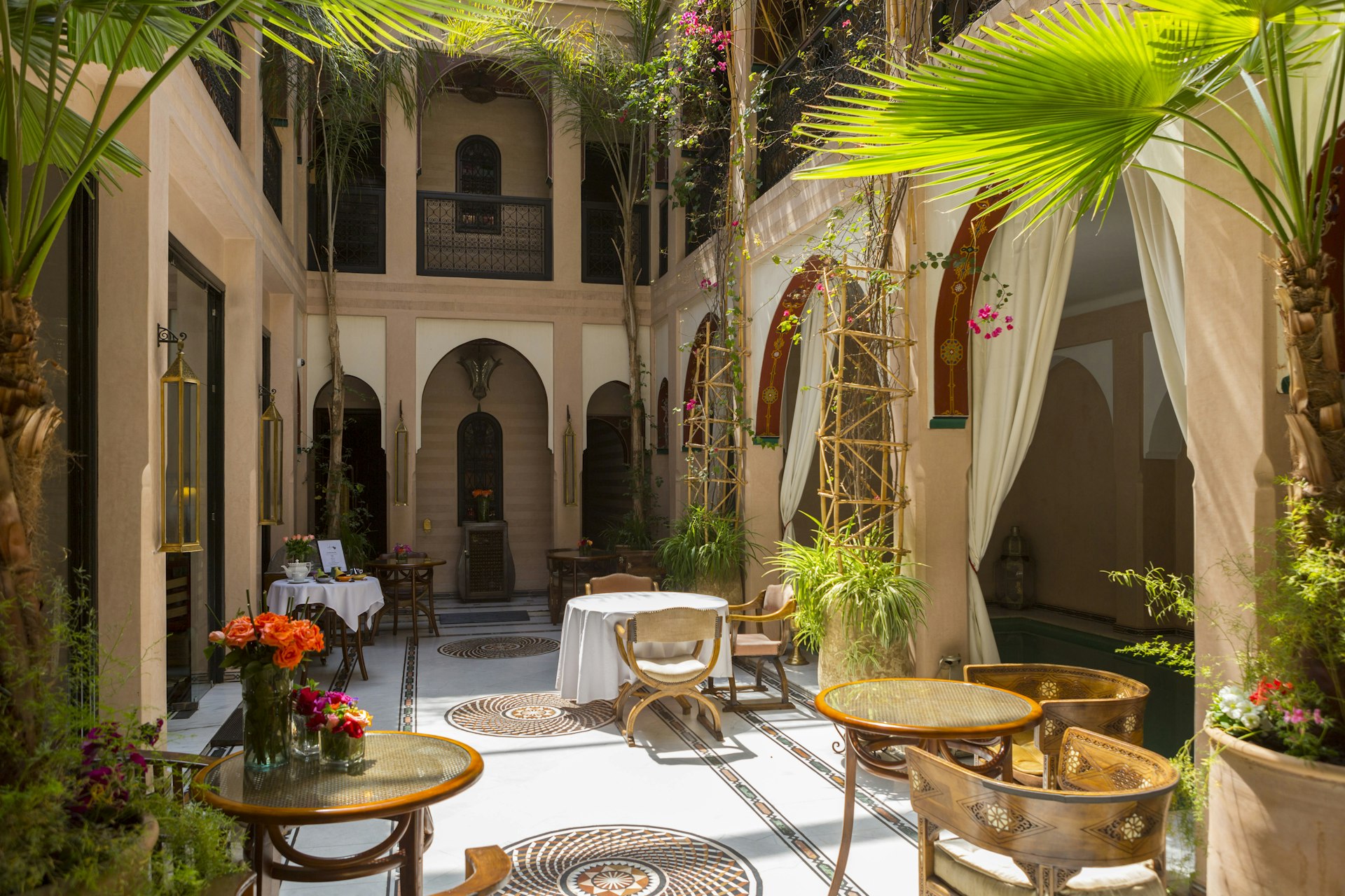 The communal area in a riad courtyard with chairs, tables and plants