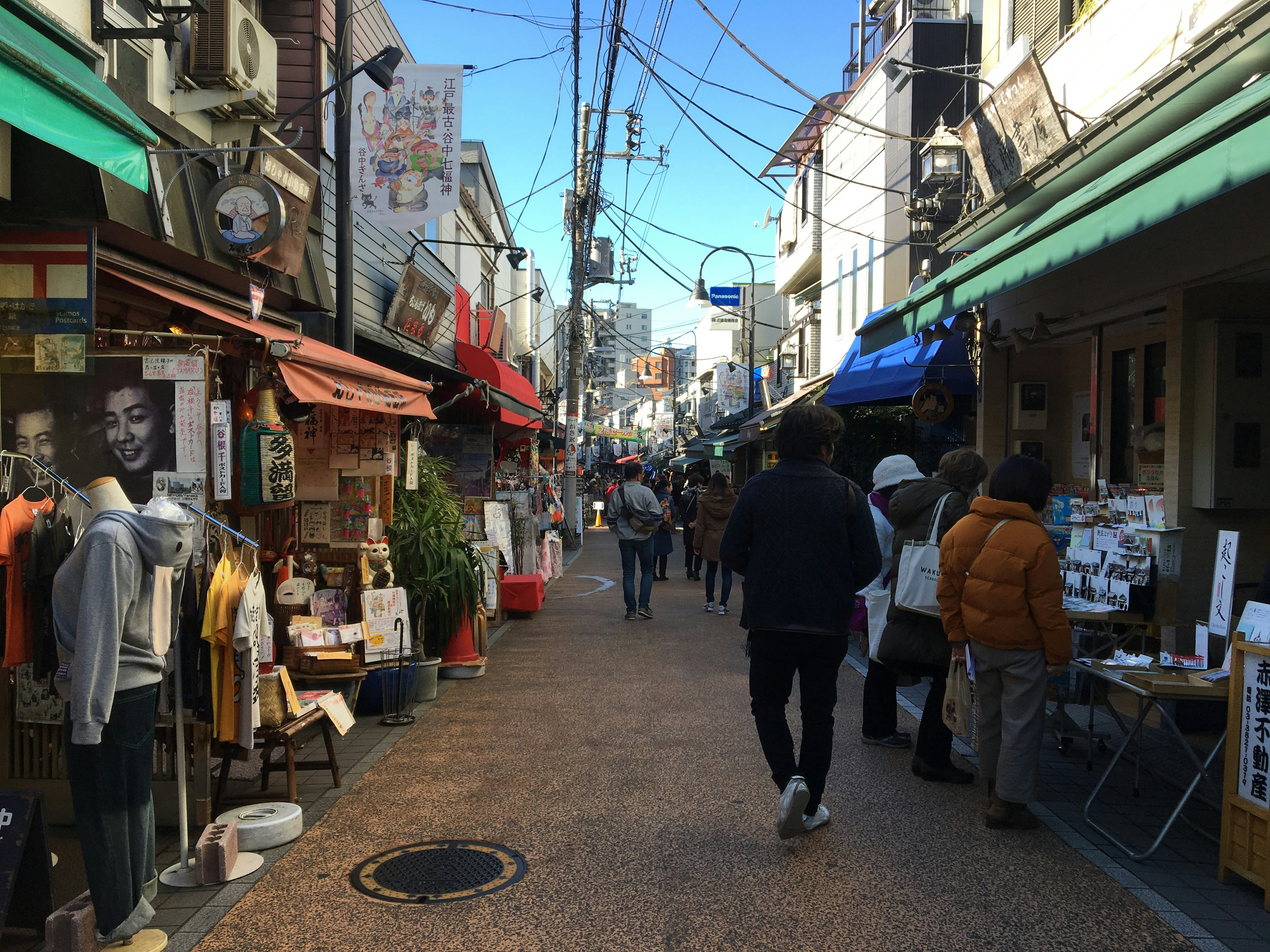 shoppers browsing stalls in a shopping street in Yanesen