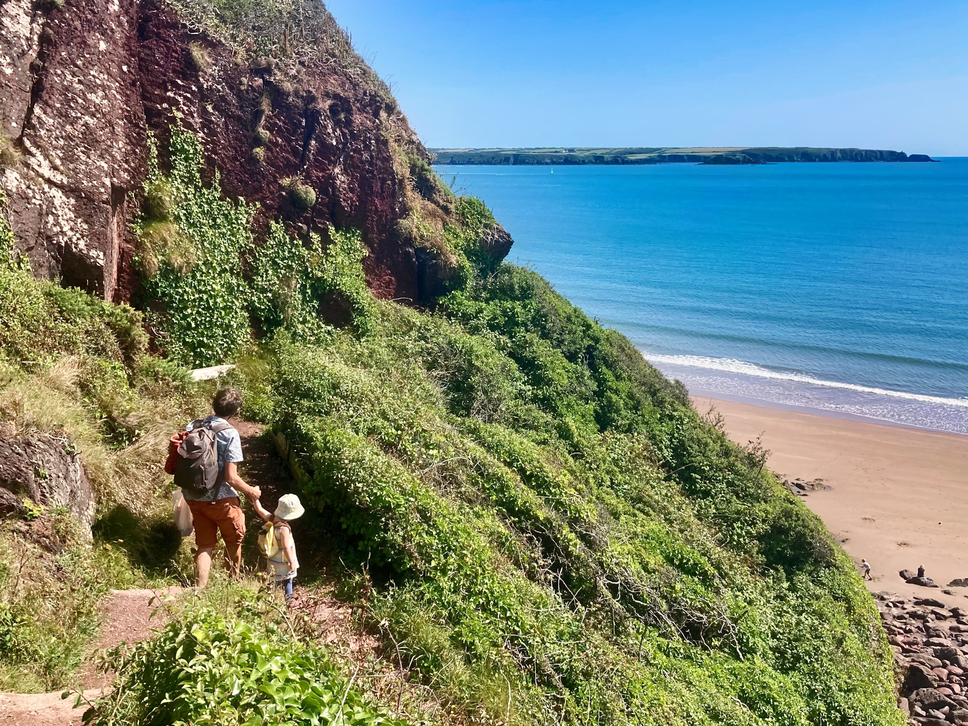 Father and daughter walk the trail path to Lindsway Bay