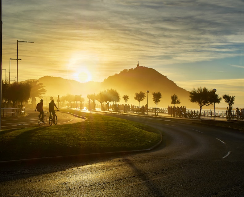 The sun sets behind the Monte Urgull of San Sebastian, Basque Country, Guipuzcoa. Spain. View from Zurriola Avenue.