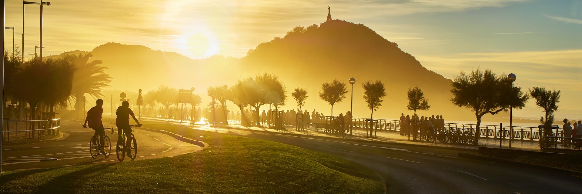 The sun sets behind the Monte Urgull of San Sebastian, Basque Country, Guipuzcoa. Spain. View from Zurriola Avenue.