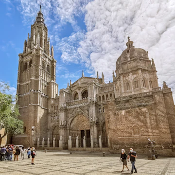 Toledo / Spain - 05 12 2021: Amazing view at the plaza del ayuntamiento in Toledo, Primate Cathedral of Saint Mary of Toledo main front facade, Santa Iglesia Catedral Primada de Toledo, otherwise Toledo Cathedral, a Roman Catholic church, tourist people visiting.