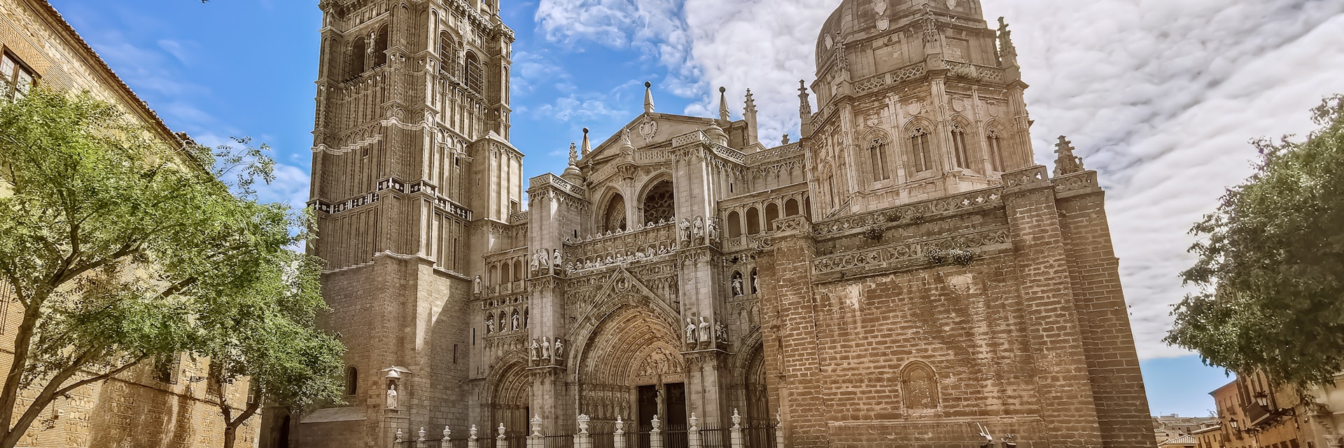 Toledo / Spain - 05 12 2021: Amazing view at the plaza del ayuntamiento in Toledo, Primate Cathedral of Saint Mary of Toledo main front facade, Santa Iglesia Catedral Primada de Toledo, otherwise Toledo Cathedral, a Roman Catholic church, tourist people visiting.