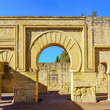 Ruins of medieval Arabic palace with columns and arched doors. Cordoba Medina Azahara.