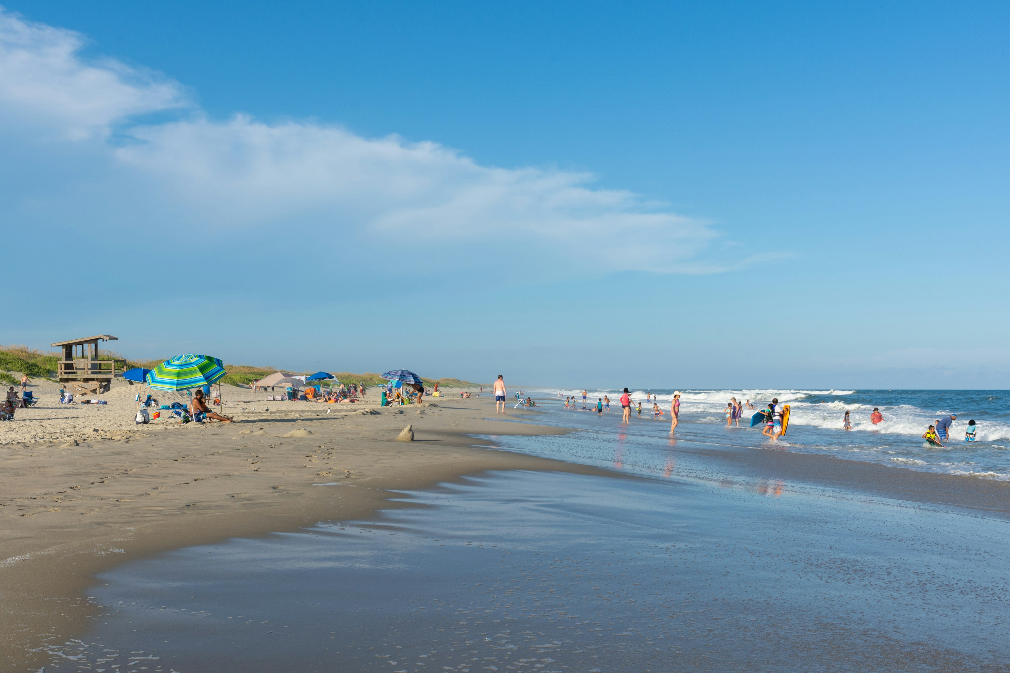 People relaxing and playing on a sandy beach on a sunny day