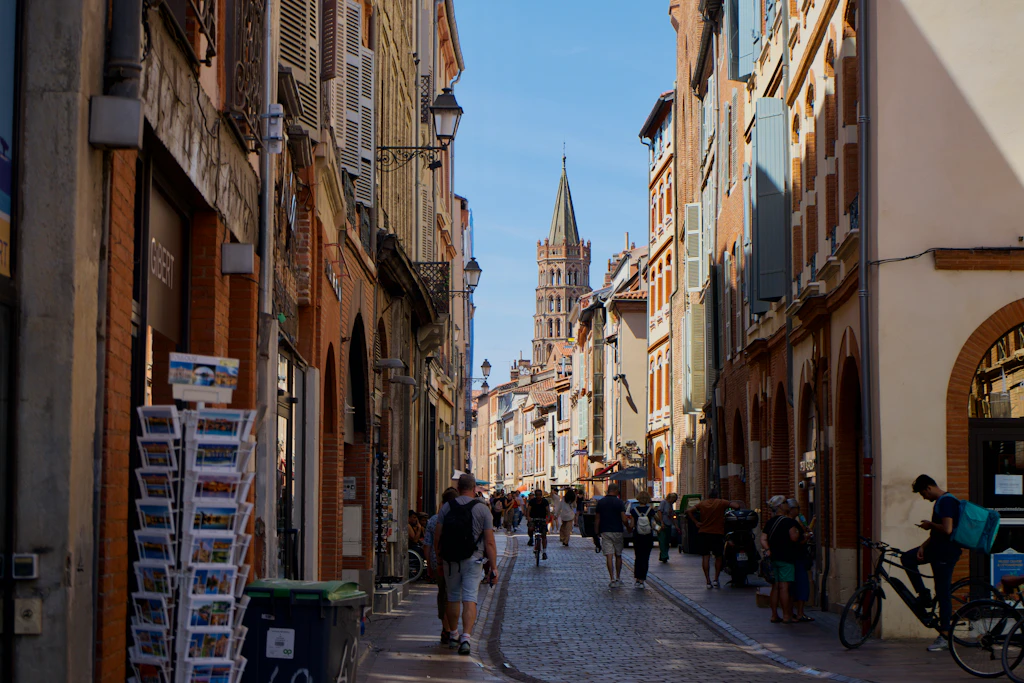 Rue du Taur, Toulouse A narrow pedestrianized street leading to a church with a tall pointed spire