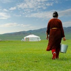 Mongolian farmer carrying bucket of milk after milking cow   in the grassland of Mongolia; Shutterstock ID 1157874577; your: Claire Naylor; gl: 65050; netsuite: Online ed; full: Mongolia best things to do
1157874577
