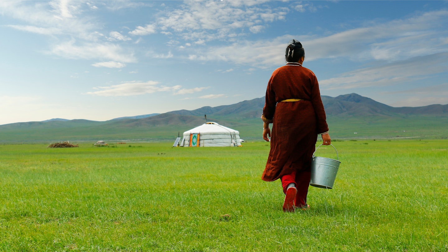 Mongolian farmer carrying bucket of milk after milking cow in the grassland of Mongolia; Shutterstock ID 1157874577; your: Claire Naylor; gl: 65050; netsuite: Online ed; full: Mongolia best things to do 1157874577