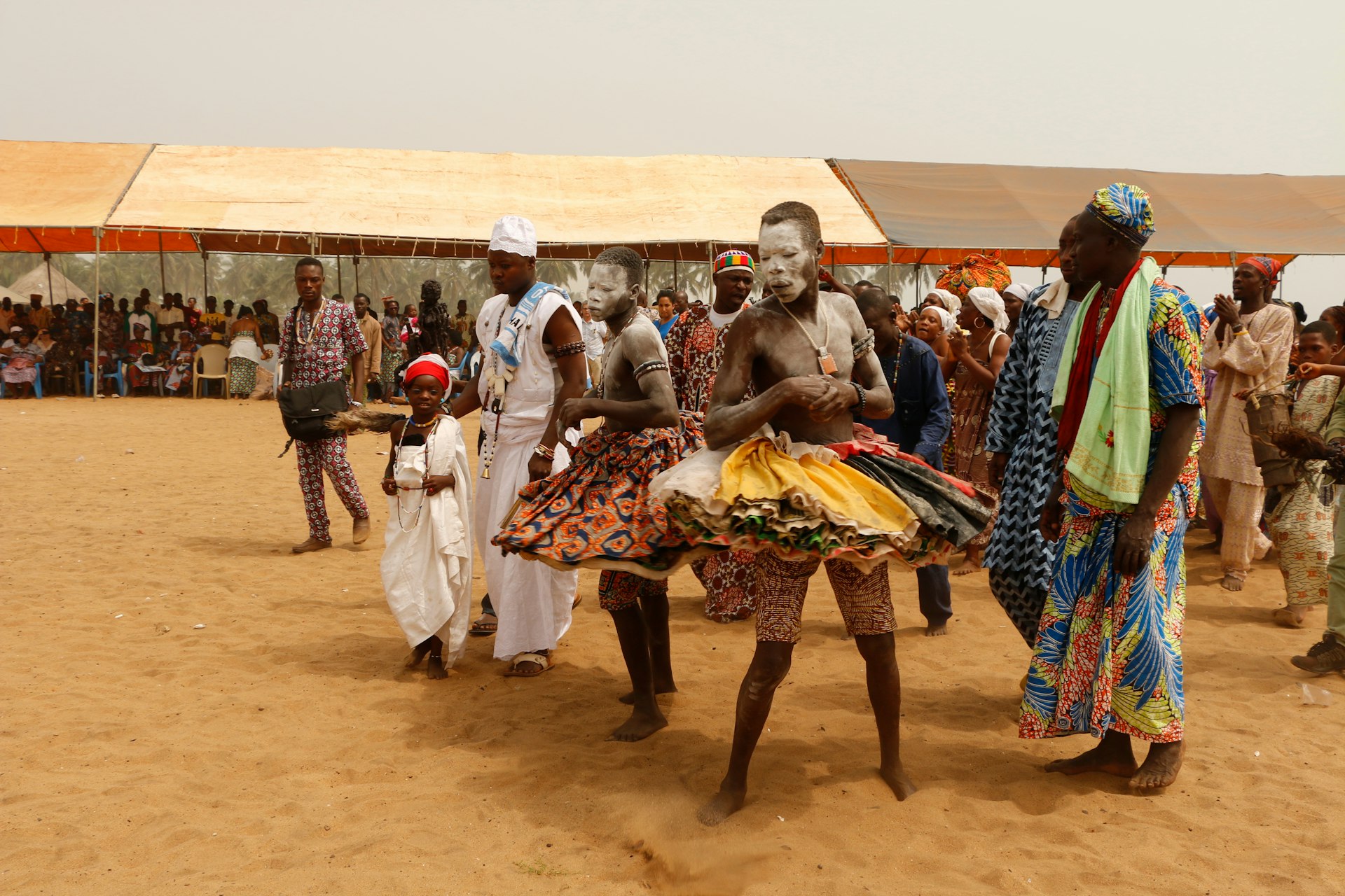 Men with their faces painted dancing during a voodoo festival in Benin