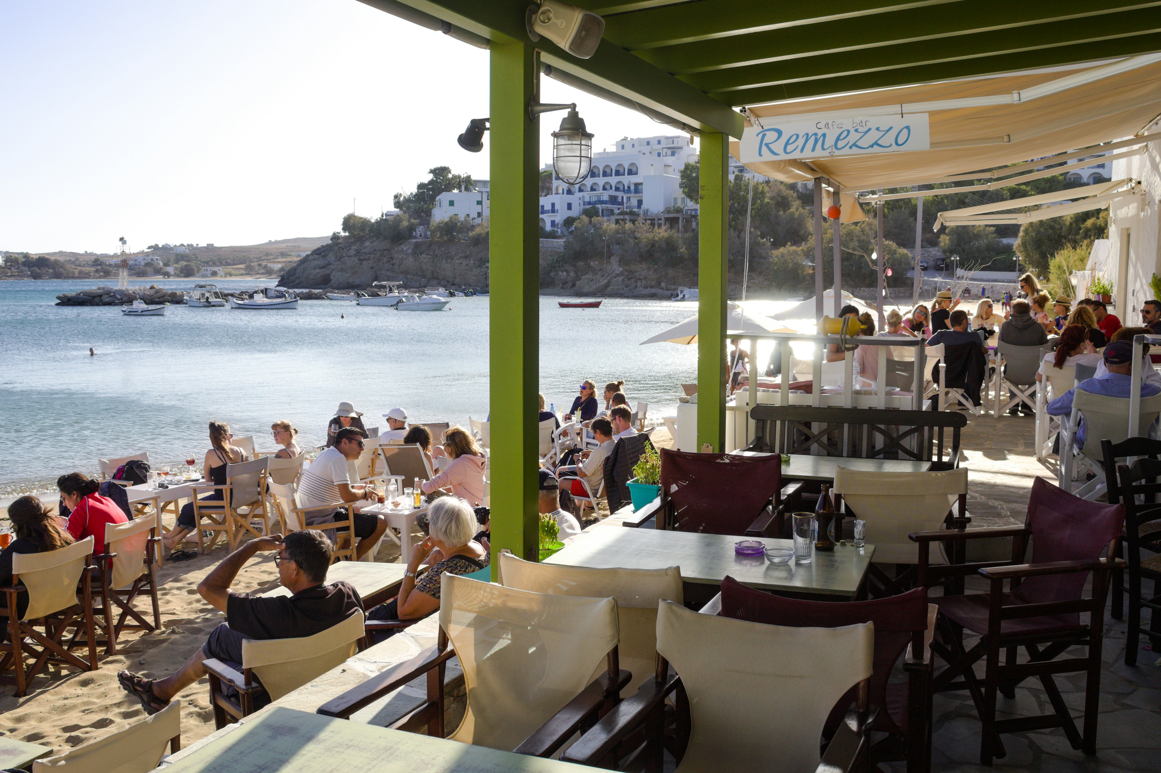 Holidaymakers relax at a beach bar in the small village of Piso Livadi