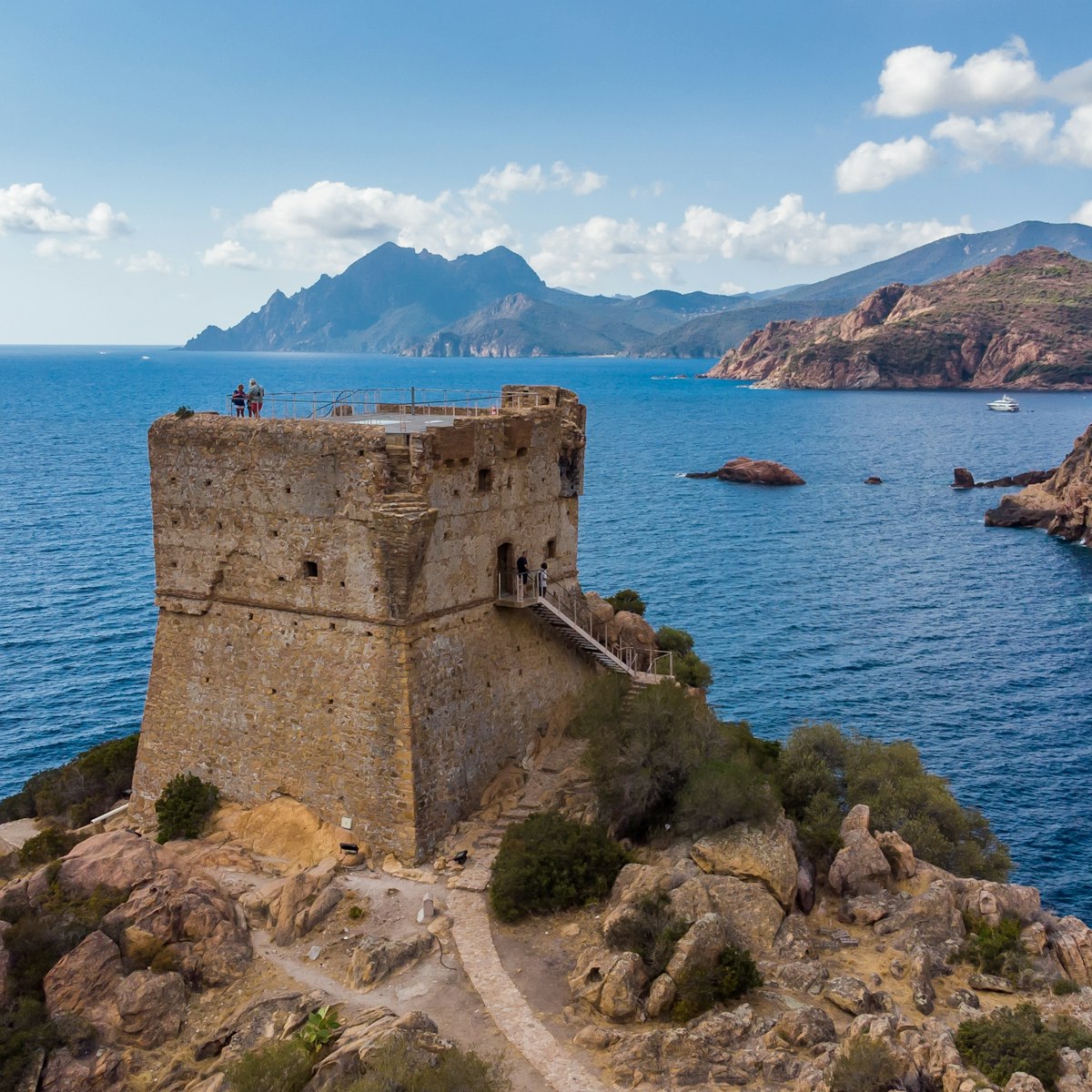 Aerial view of the ruins of the square Genoese tower of Porto at the end of the Gulf of Porto, Corsica, France.