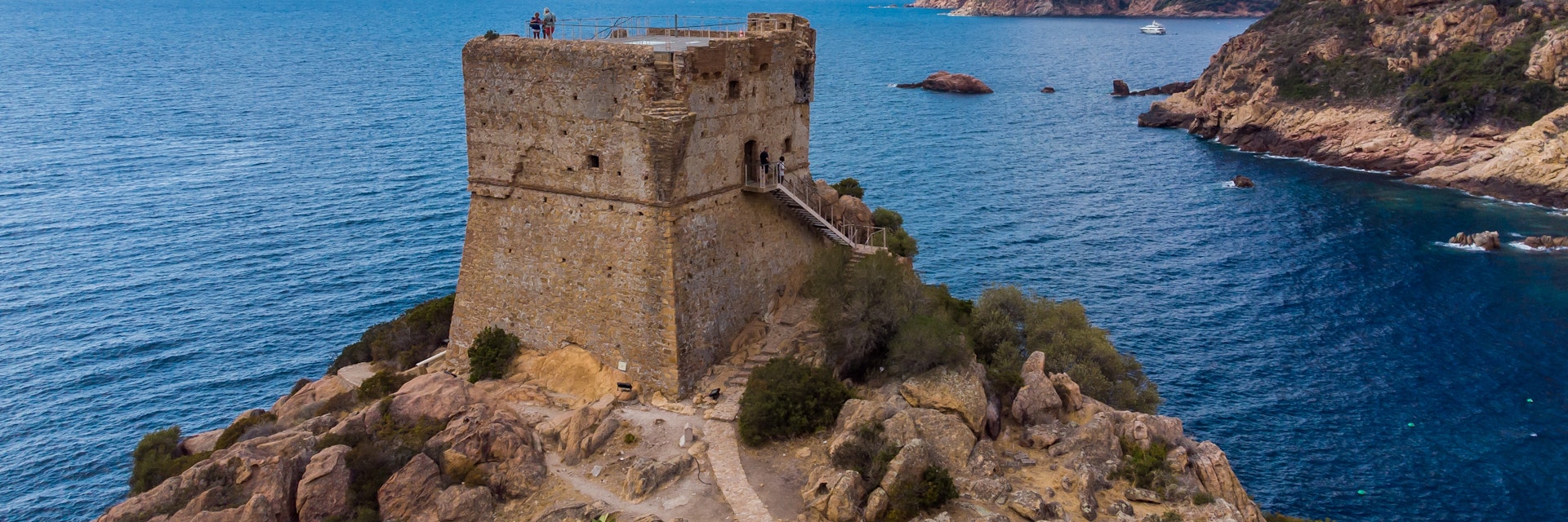 Aerial view of the ruins of the square Genoese tower of Porto at the end of the Gulf of Porto, Corsica, France.