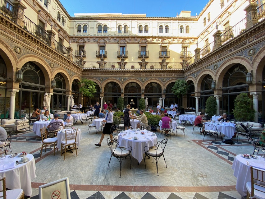 Seville, Spain. Breakfast tables in the interior courtyard of the historical Hotel Alfonso XIII, a Luxury Collection Hotel.
