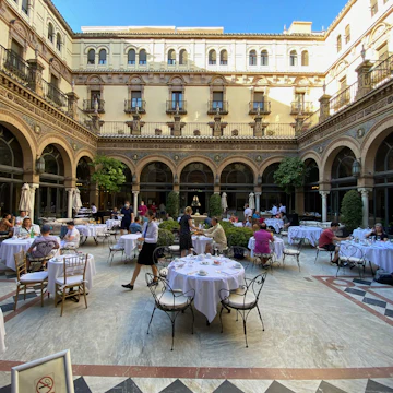Seville, Spain. Breakfast tables in the interior courtyard of the historical Hotel Alfonso XIII, a Luxury Collection Hotel.