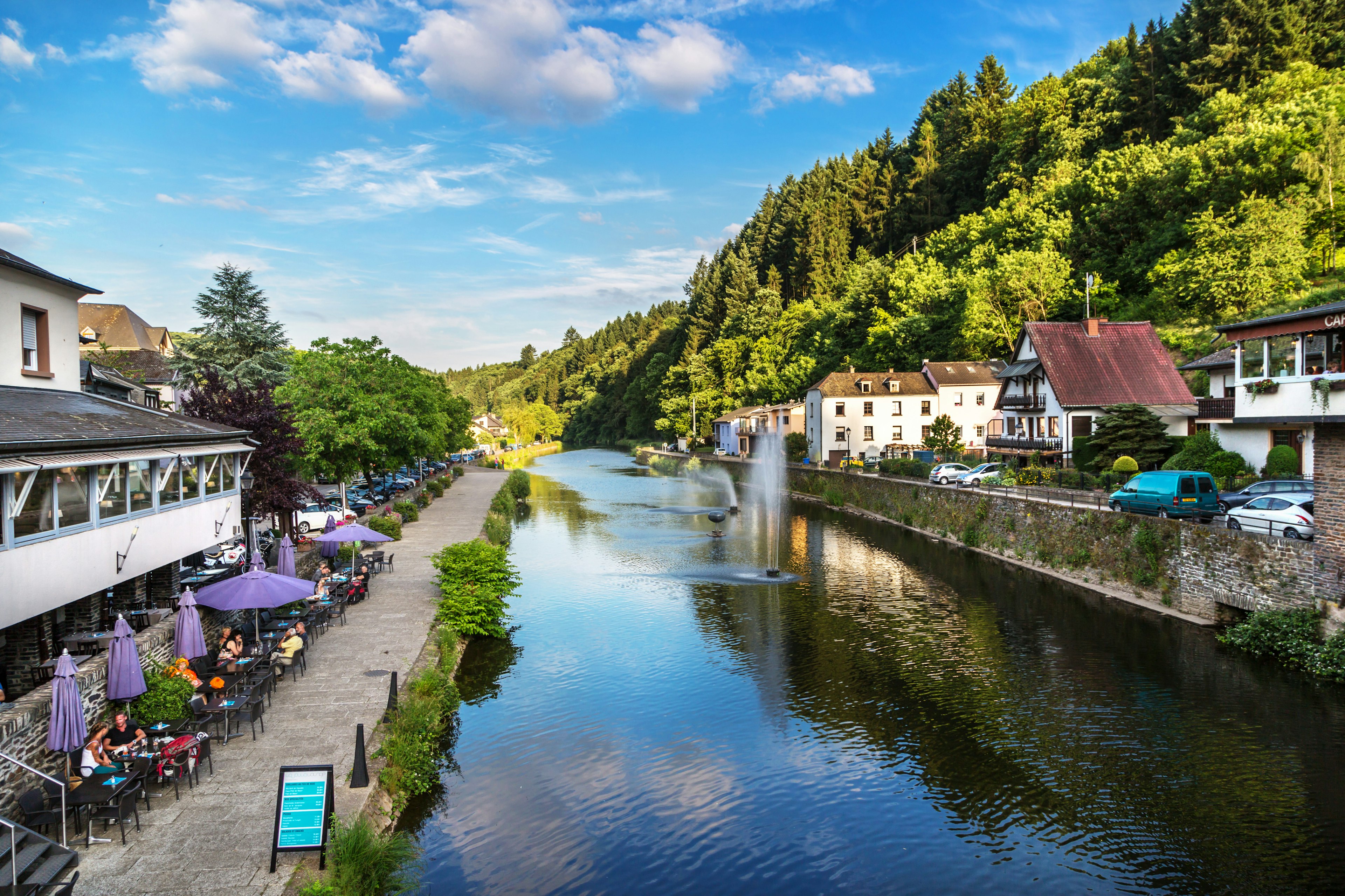 Diners sit at outside tables at a riverside restaurant