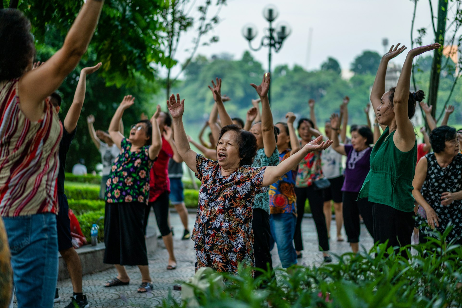 A group of people exercising together at a park in Hanoi.