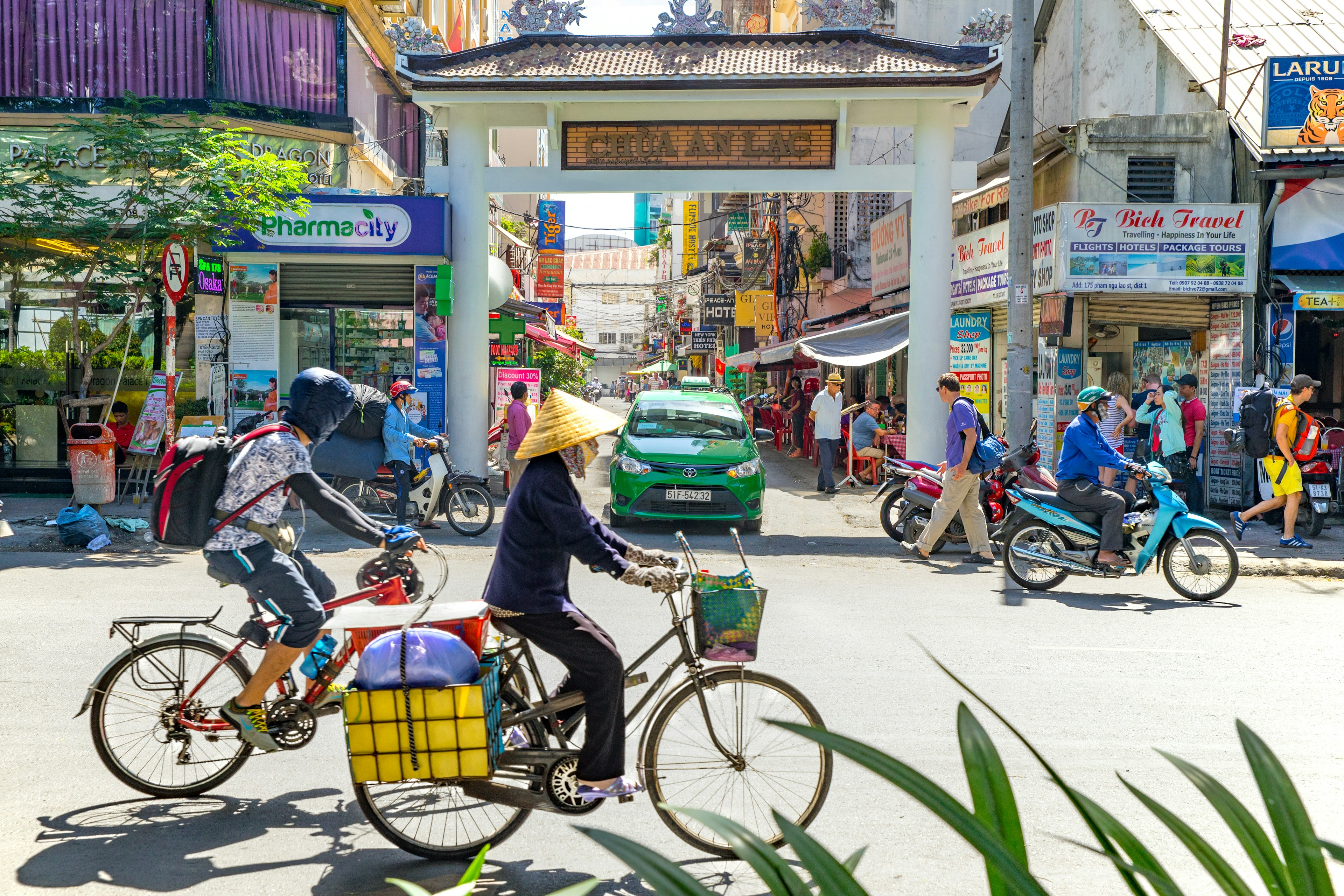 Cyclists and pedestrians on Pham Ngu Lao street in the backpacker district of Ho Chi Minh.