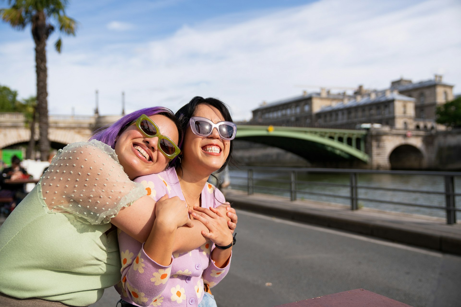 Cheerful friends smiling in Paris by the River Seine