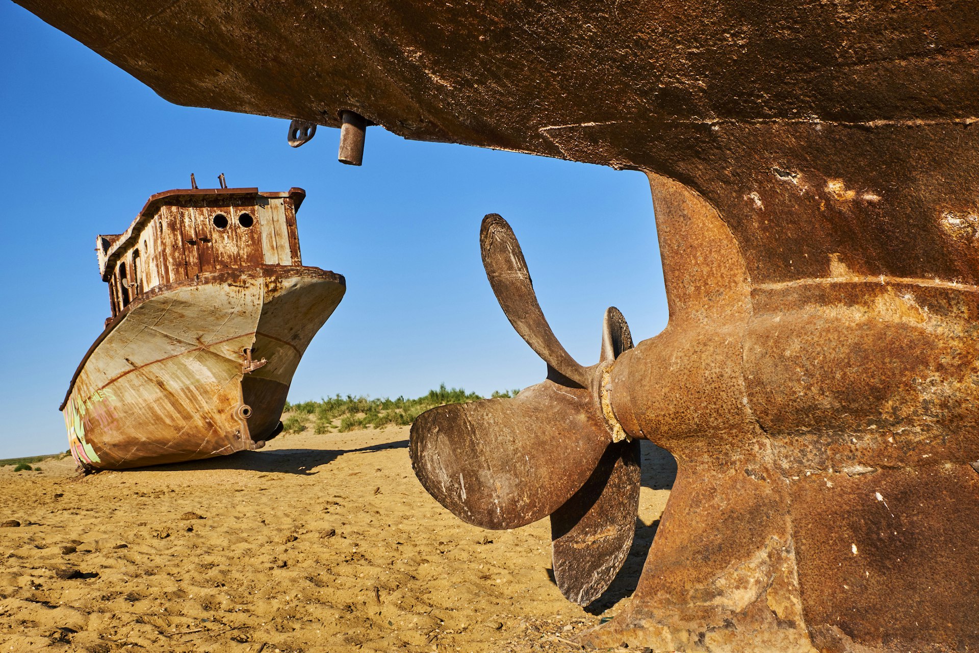 Rusting hulls of two ships on dry land