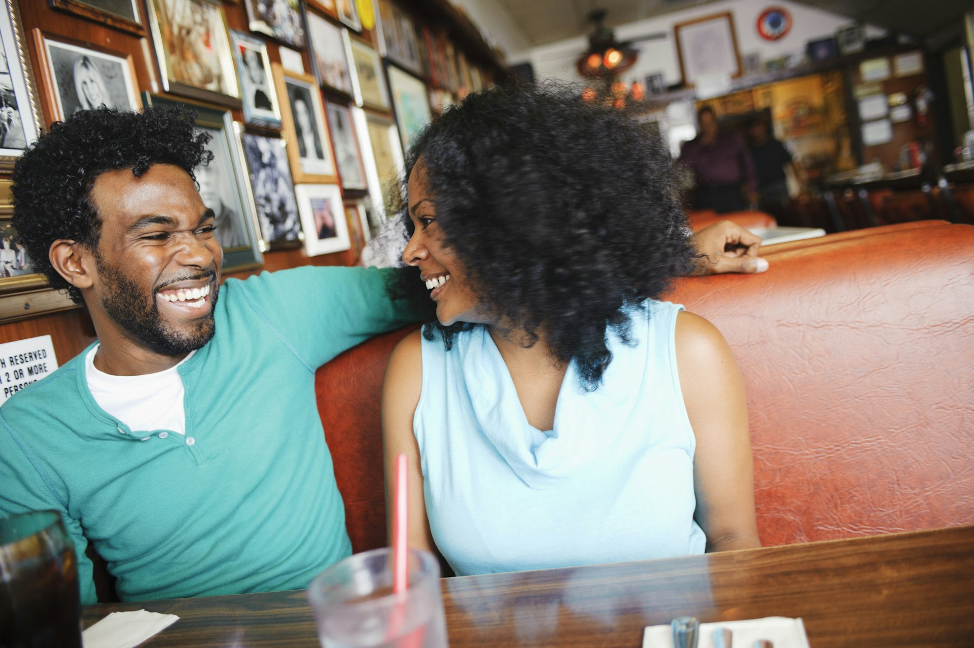 A couple smiling at each other in a booth at a restaurant in California
