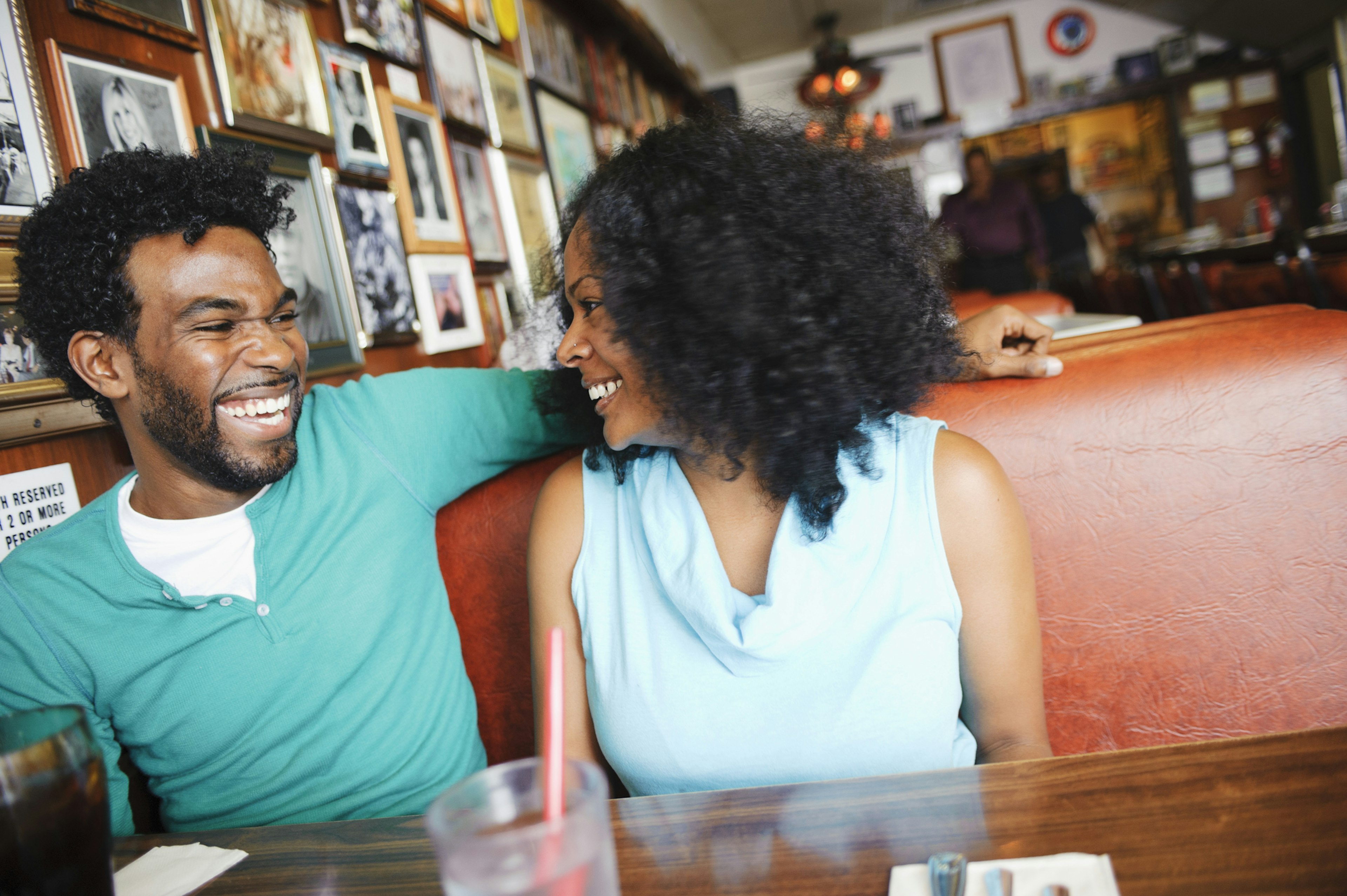 A couple smiling at each other in a booth at a restaurant in California