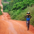 A woman walking on an unsurfaced road near Ouidah in Benin