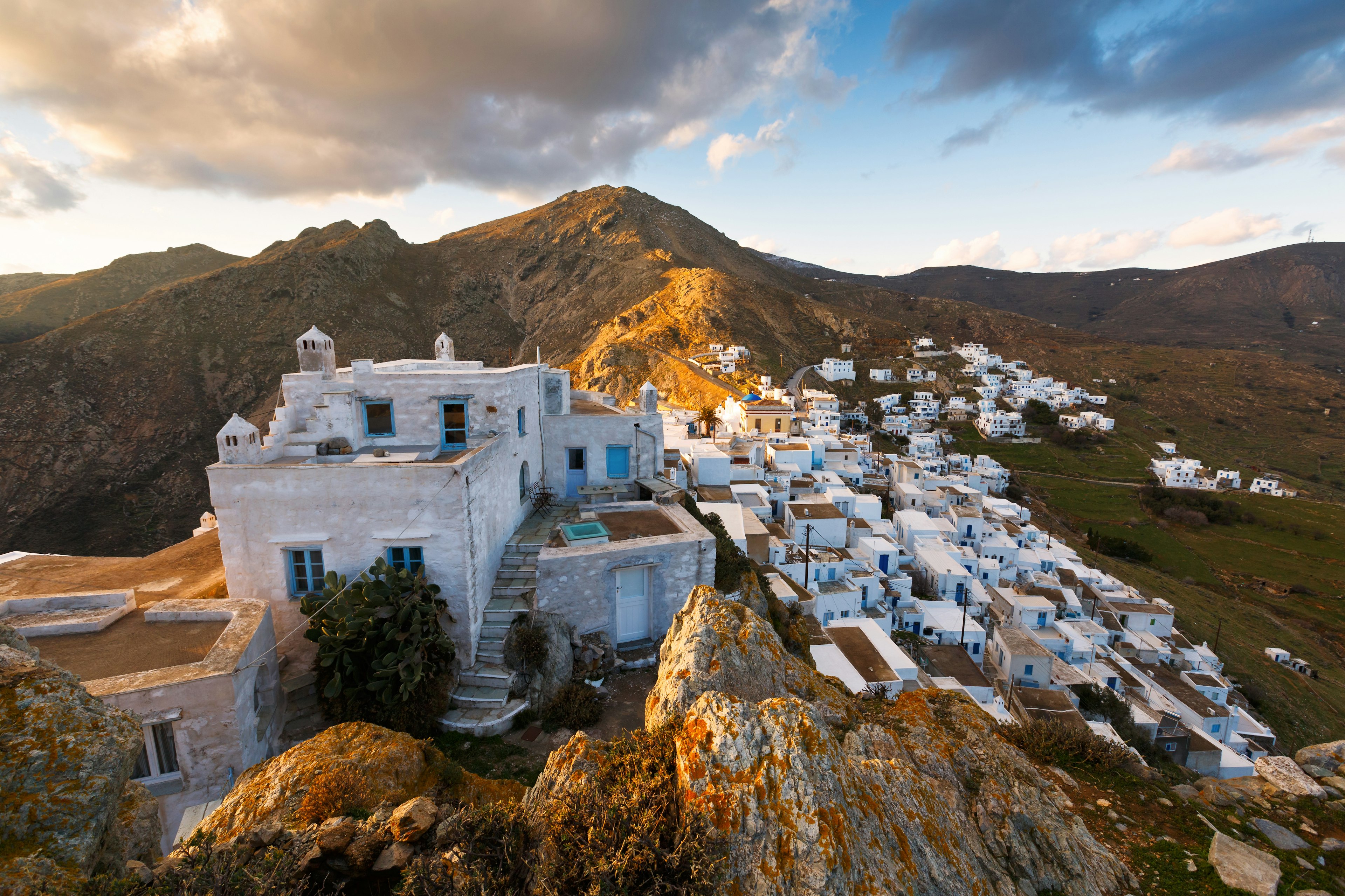 Aerial view of a low-rise village of white buildings on the side of a hill