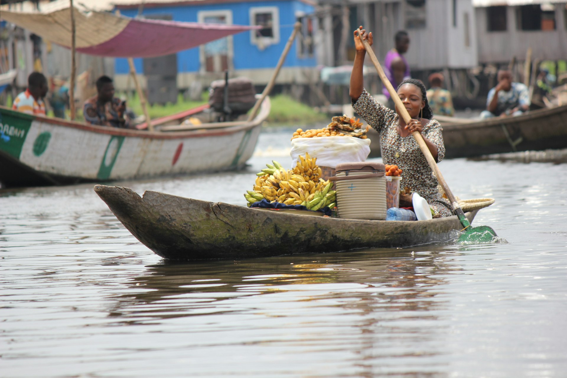 A woman canoes through the water at of Lake Nokoué from Ganvié, Benin 