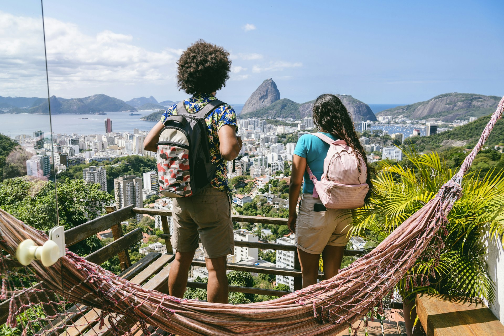 Two backpackers looking at view of Sugarloaf, Rio de Janeiro