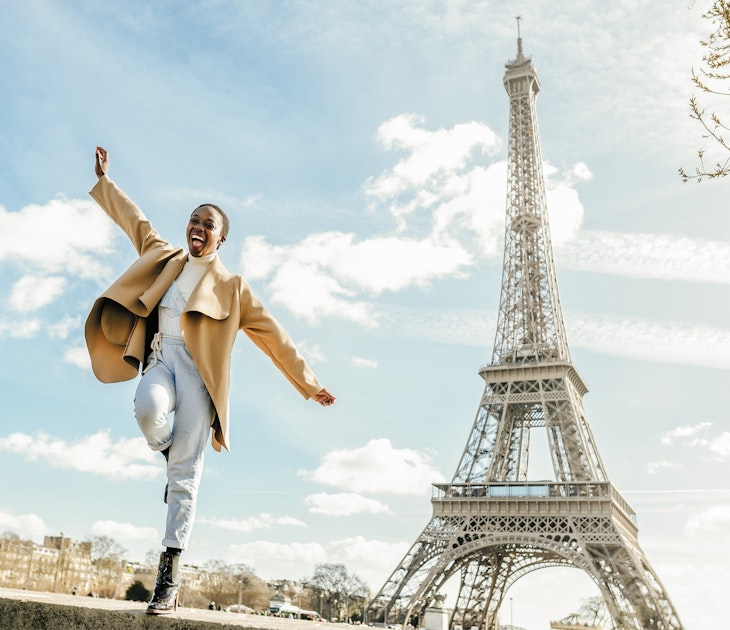 A Black woman dancing near the Eiffel Tower in Paris